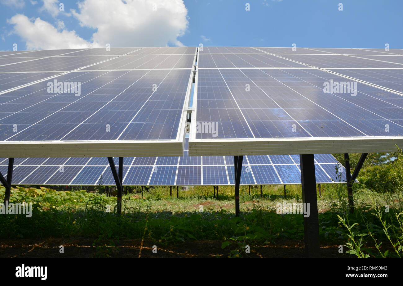 Solar panels with beautiful clouds sky in the house backyard. Stock Photo