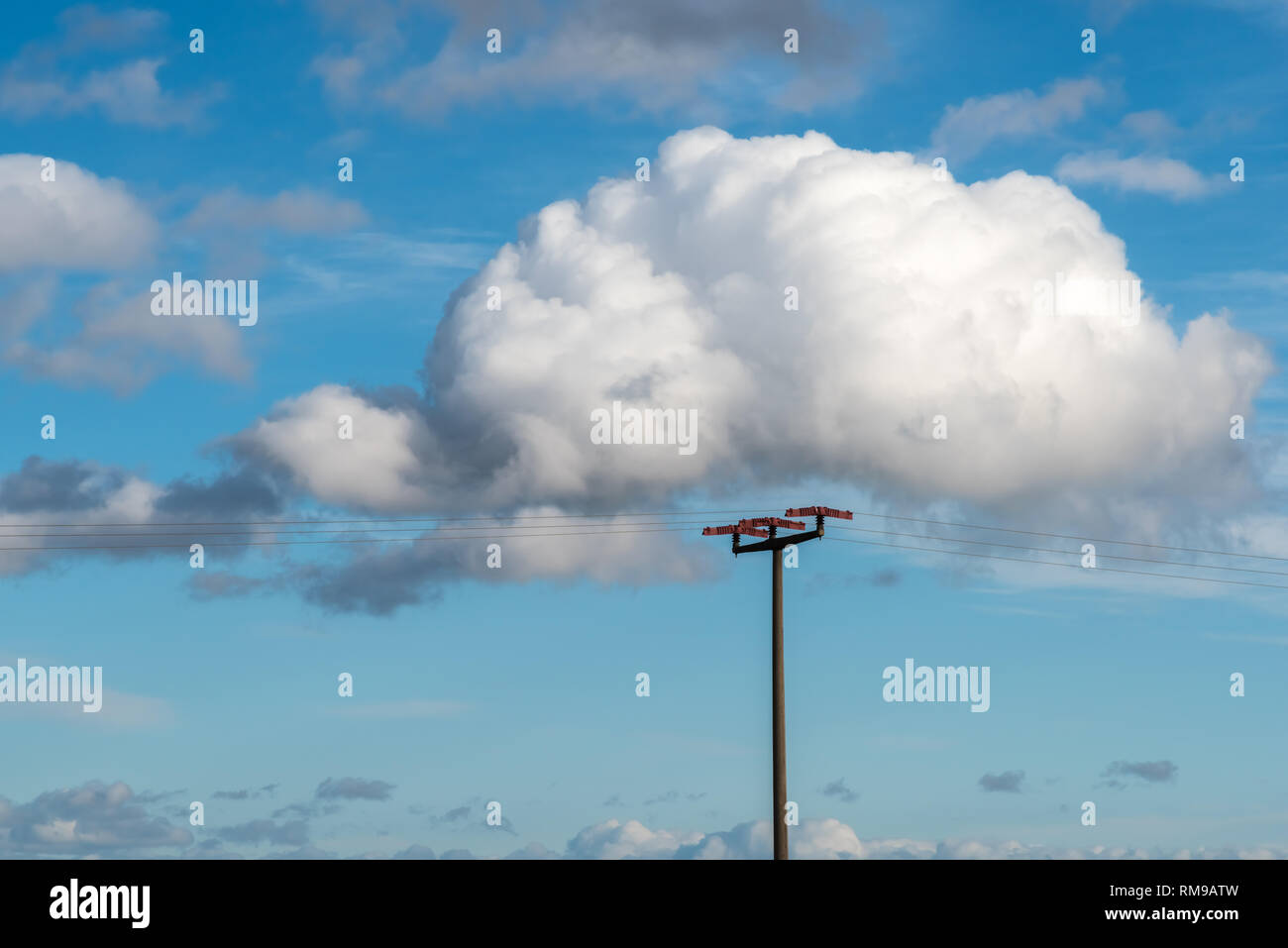 The cloud on the horizon envelops the power pole Stock Photo