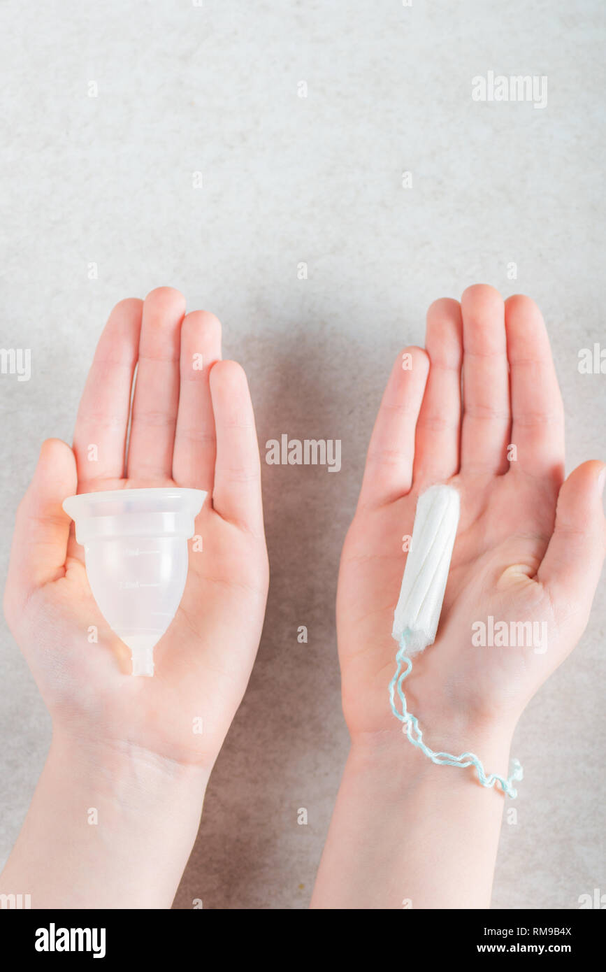 Woman is holding hygiene items for critical days in her hands, such as