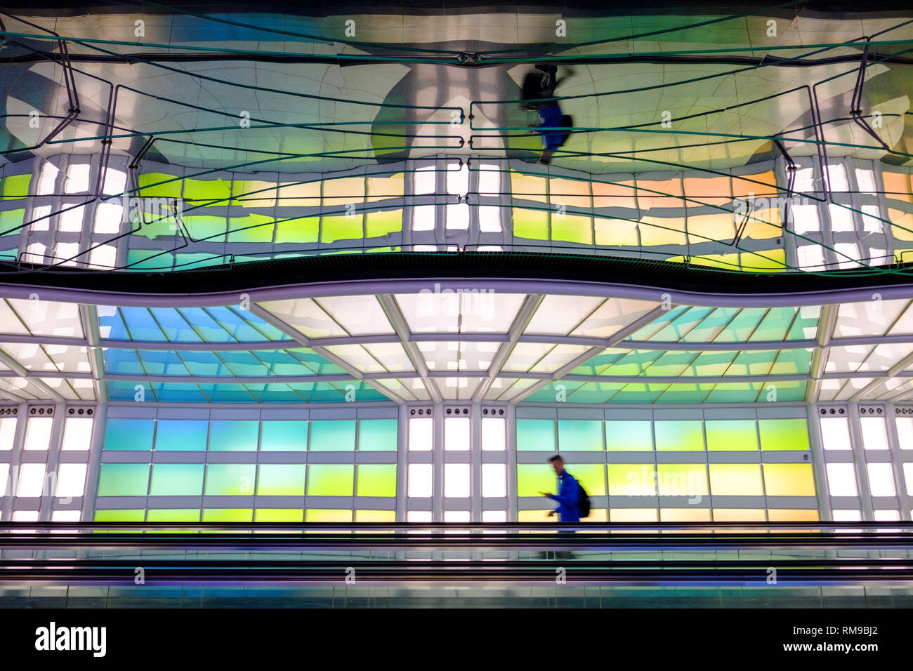 Air passenger, a person walking, neon lights art installation, Michael Hayden, pedestrian tunnel, Chicago O'Hare International Airport Terminal, USA Stock Photo