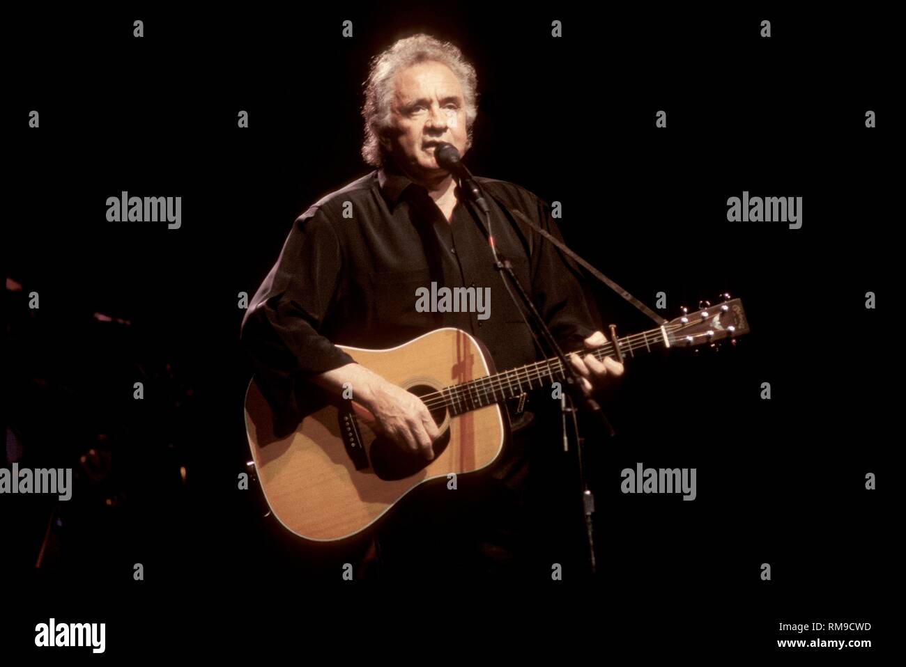 Grammy Award winning singer and songwriter Johnny Cash is shown performing on stage with the country super group the Highwaymen. Stock Photo