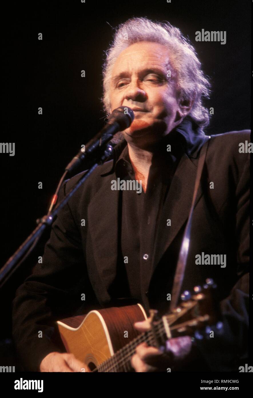 Grammy Award winning singer and songwriter Johnny Cash is shown performing on stage with the country super group the Highwaymen. Stock Photo