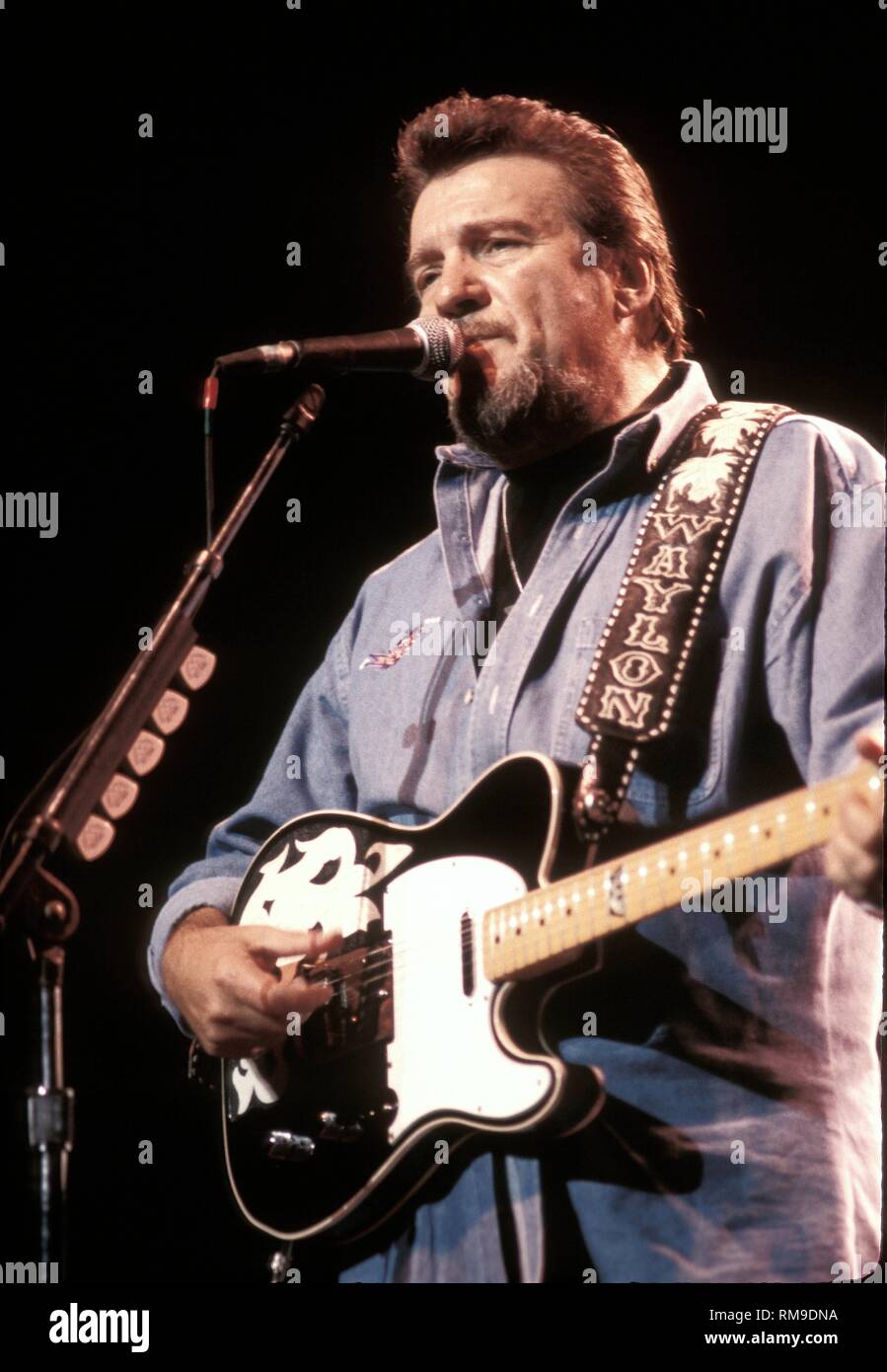 Influential country music singer and musician Waylon Jennings is shown performing on stage during a 'live' concert appearance. Stock Photo