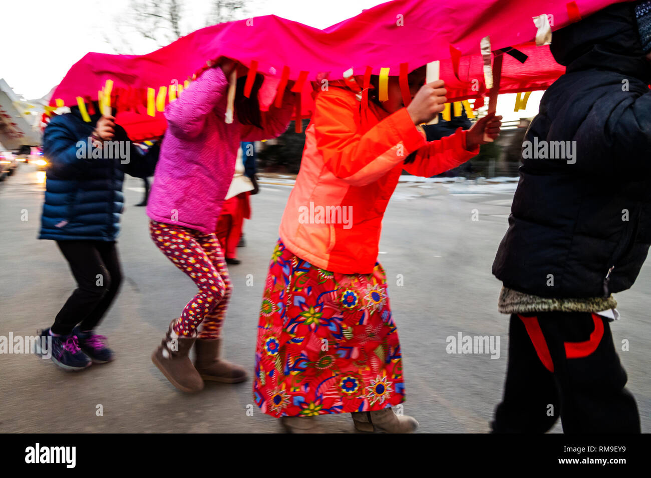 Pan blur motion image of children dancing in fancy costumes at Salida's 3rd annual Lunar New Year Parade. The year of the Pig. Stock Photo