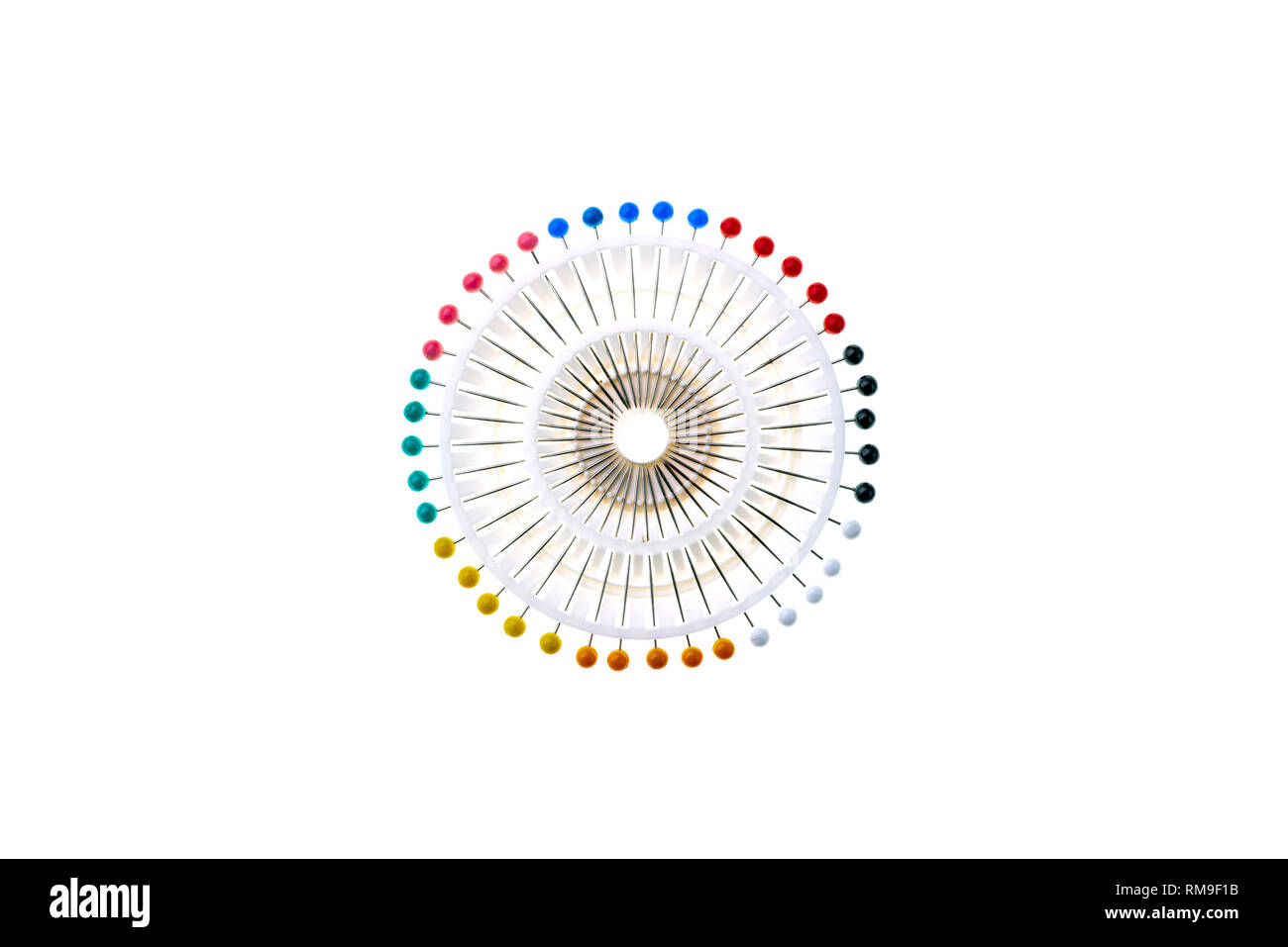 Set of colourful round headed or berry pins,  in a white plastic holder forming an abstract image. Stock Photo