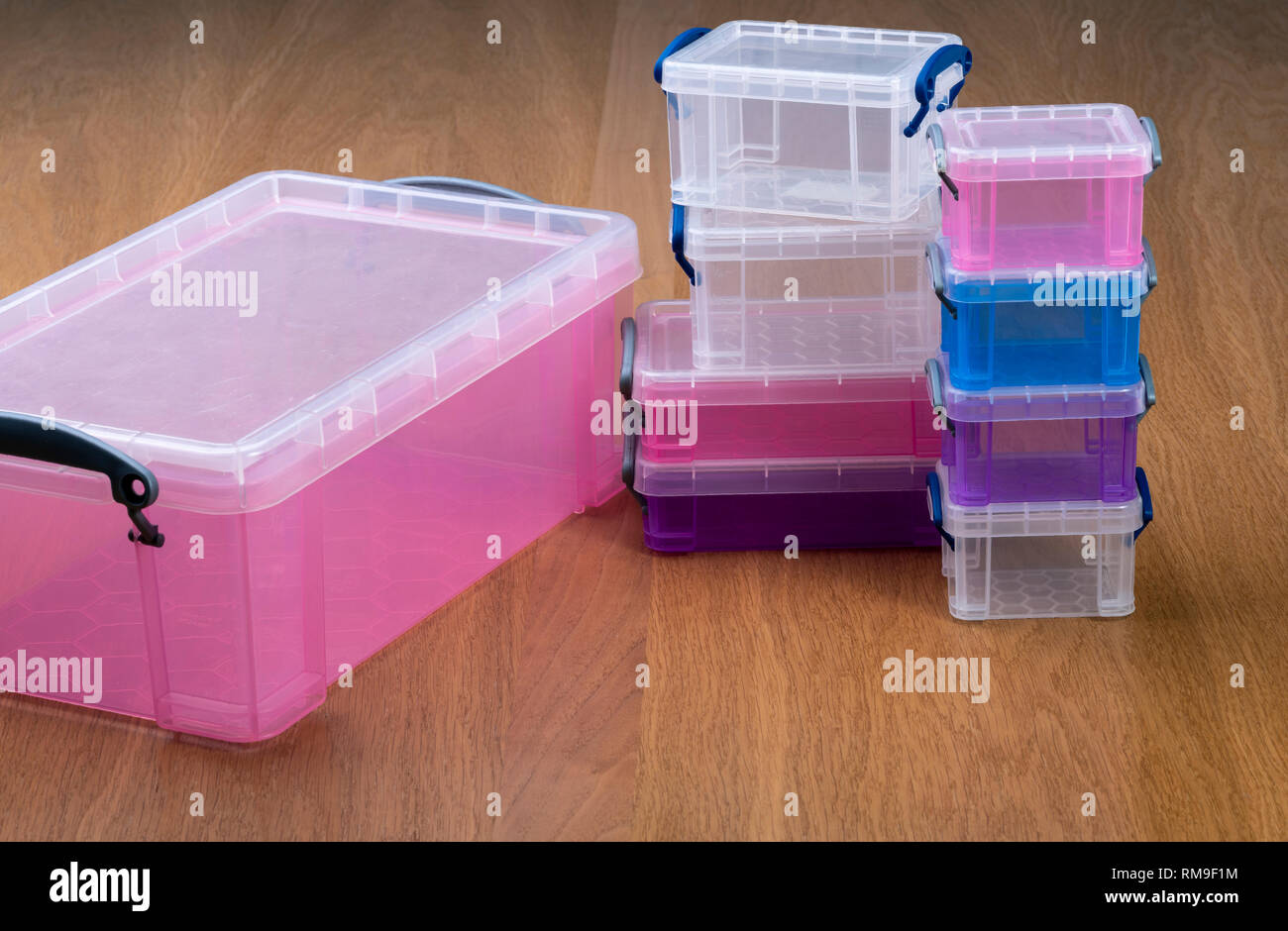 Plastic storage boxes or crates on a wooden table. Stock Photo