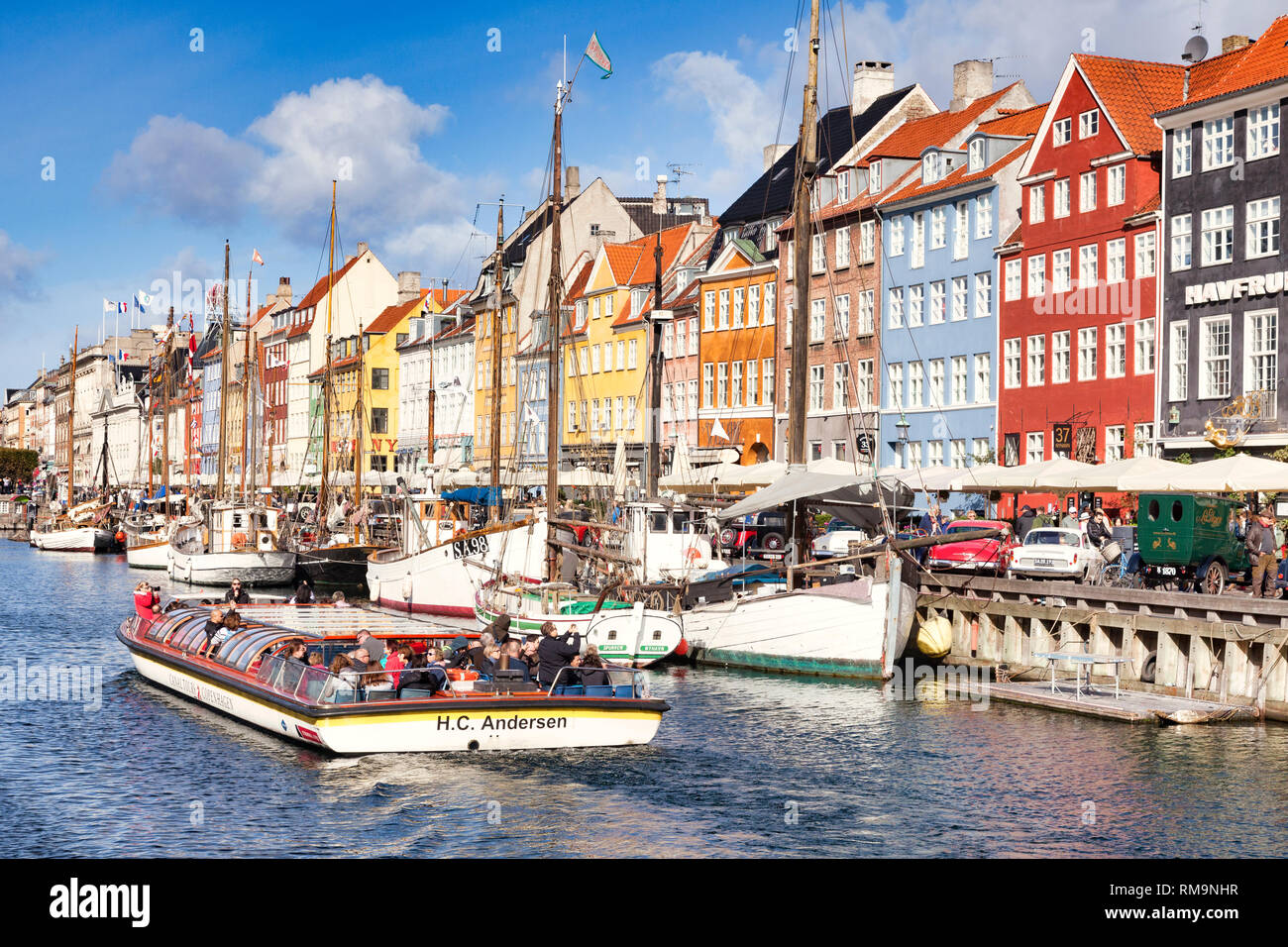 23 September 2018: Copenhagen, Denmark - Canal boat full of tourists sightseeing along the canal in the Copenhagen district of Nyhavn, with its colour Stock Photo