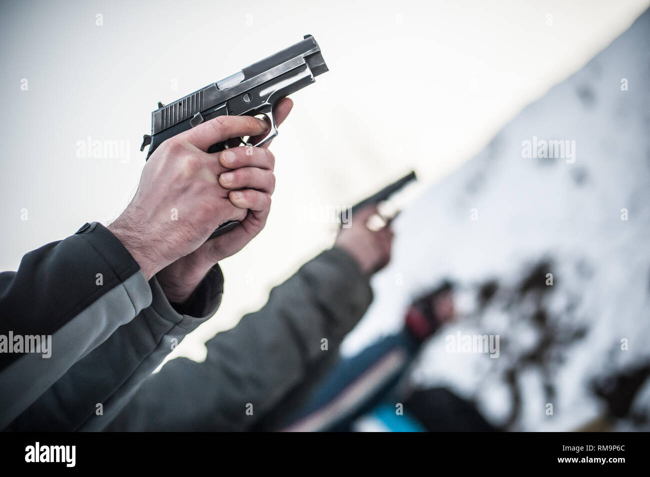 Close-up detail view of shooter practice handgun shooting on target in ...