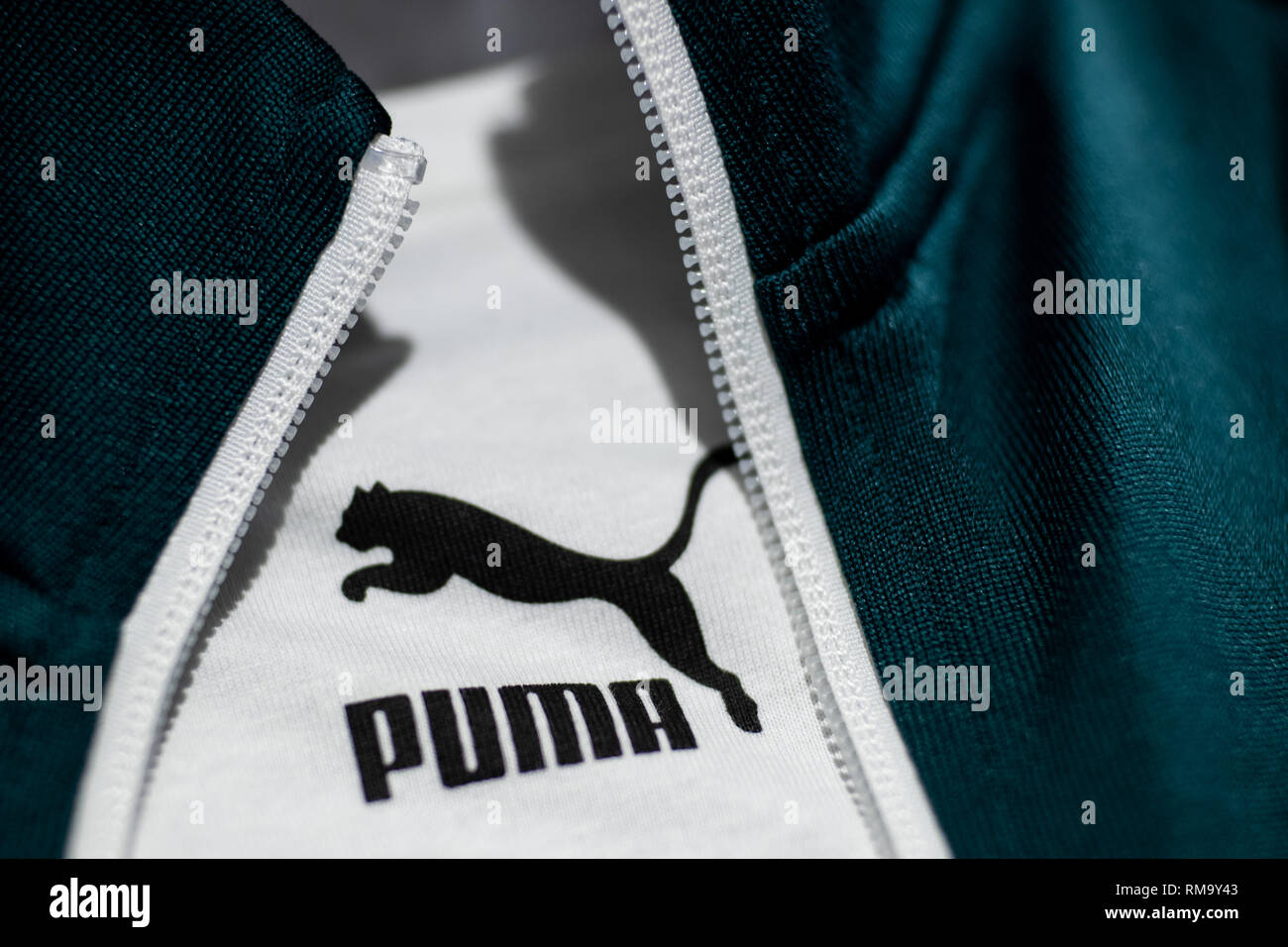 Herzogenaurach, Germany. 14th Feb, 2019. A T-shirt with the logo of the  sporting goods manufacturer Puma SE hangs in the company between the zipper  of a training jacket. On 14 February, the