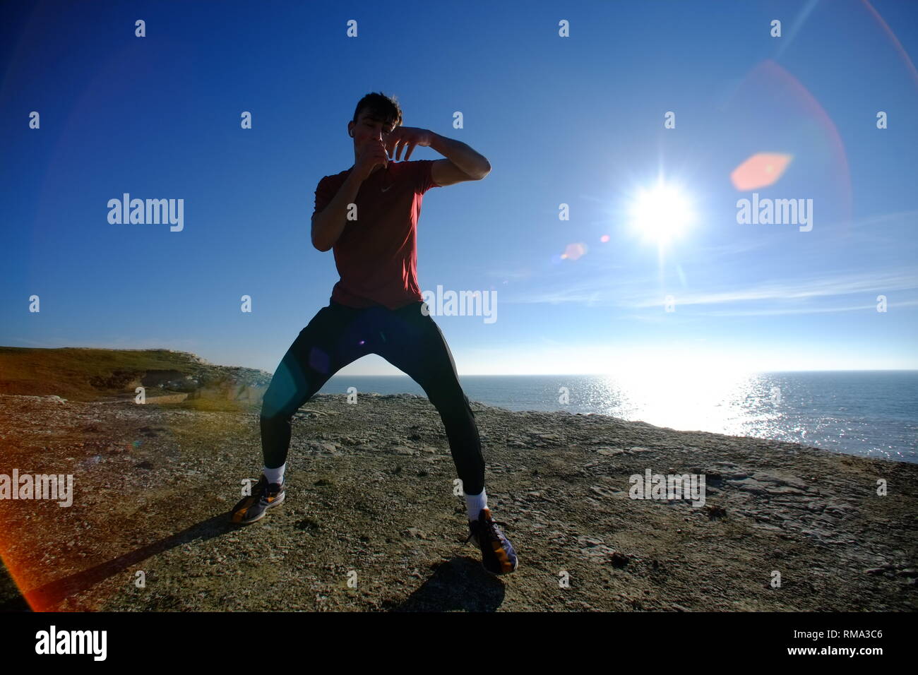 Seaford, East Sussex, UK. 14th Feb, 2019. People enjoying the bright warm sunshine on Seaford Beach, pictured is Sonny Parkinson shadow boxing on the chalk cliffs above Seaford. Credit: Peter Cripps/Alamy Live News Stock Photo