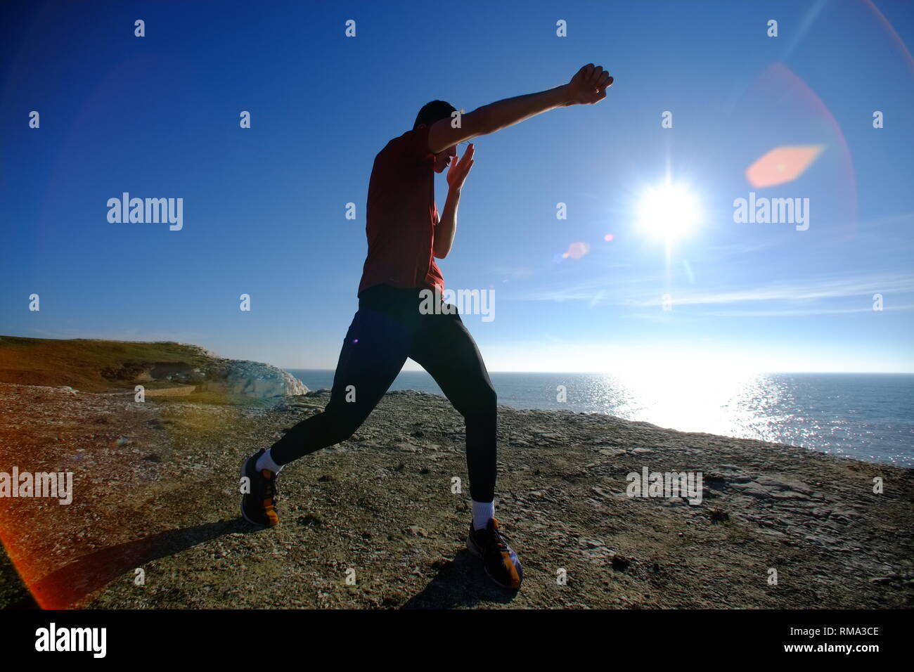 Seaford, East Sussex, UK. 14th Feb, 2019. People enjoying the bright warm sunshine on Seaford Beach, pictured is Sonny Parkinson shadow boxing on the chalk cliffs above Seaford. Credit: Peter Cripps/Alamy Live News Stock Photo