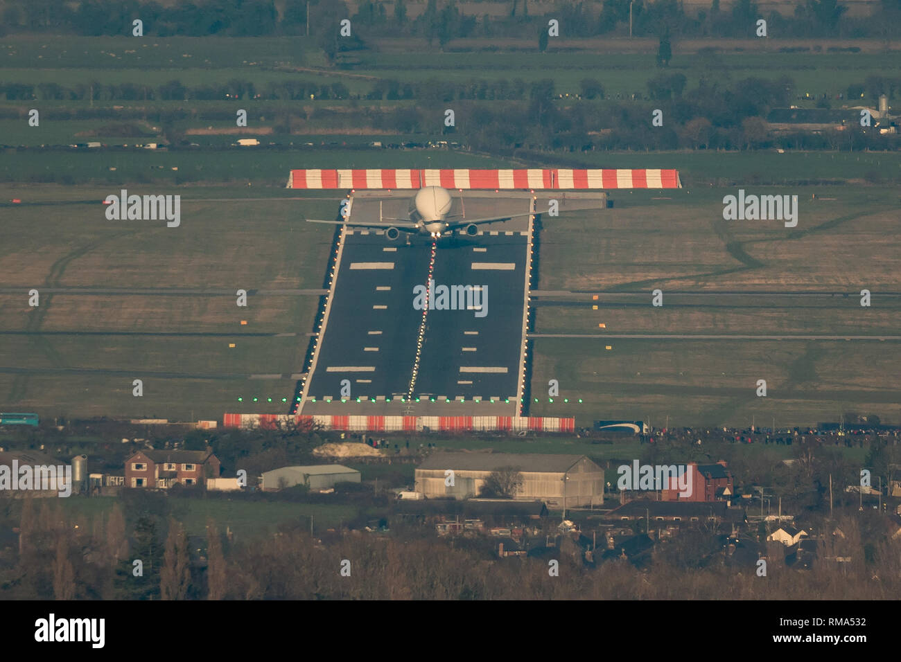 Hawarden Aerodrome/Broughton, UK. 14h February, 2019. Viewed from Waun-Y-Llyn country park, Hope Mountain, Wales, the Airbus BelugaXL lands in the UK for the first time as it visits Airbus Broughton as part of its test programme. The elevated location provides a different viewpoint with Ellesmere Port providing the backdrop and the many spectators vehicles visible on the surrounding roads Designed, built and to be operated by Airbus this successor to the Beluga will be used to move oversized aircraft components between Airbus sites. Credit: Paul Bunch / Alamy Live News. Stock Photo