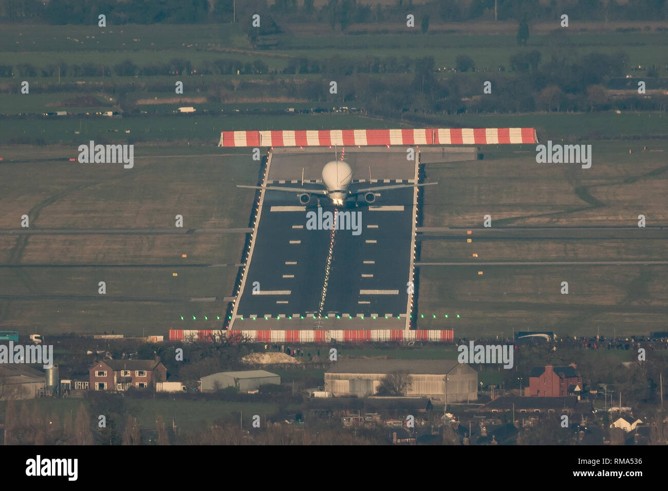 Hawarden Aerodrome/Broughton, UK. 14h February, 2019. Viewed from Waun-Y-Llyn country park, Hope Mountain, Wales, the Airbus BelugaXL lands in the UK for the first time as it visits Airbus Broughton as part of its test programme. The elevated location provides a different viewpoint with Ellesmere Port providing the backdrop and the many spectators vehicles visible on the surrounding roads Designed, built and to be operated by Airbus this successor to the Beluga will be used to move oversized aircraft components between Airbus sites. Credit: Paul Bunch / Alamy Live News. Stock Photo