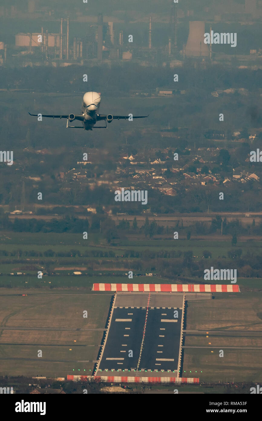 Hawarden Aerodrome/Broughton, UK. 14h February, 2019. Viewed from Waun-Y-Llyn country park, Hope Mountain, Wales, the Airbus BelugaXL lands in the UK for the first time as it visits Airbus Broughton as part of its test programme. The elevated location provides a different viewpoint with Ellesmere Port providing the backdrop and the many spectators vehicles visible on the surrounding roads Designed, built and to be operated by Airbus this successor to the Beluga will be used to move oversized aircraft components between Airbus sites. Credit: Paul Bunch / Alamy Live News. Stock Photo