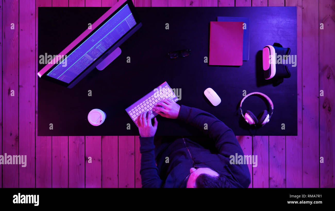 Young man programmer or hacker working on computer at night. Stock Photo
