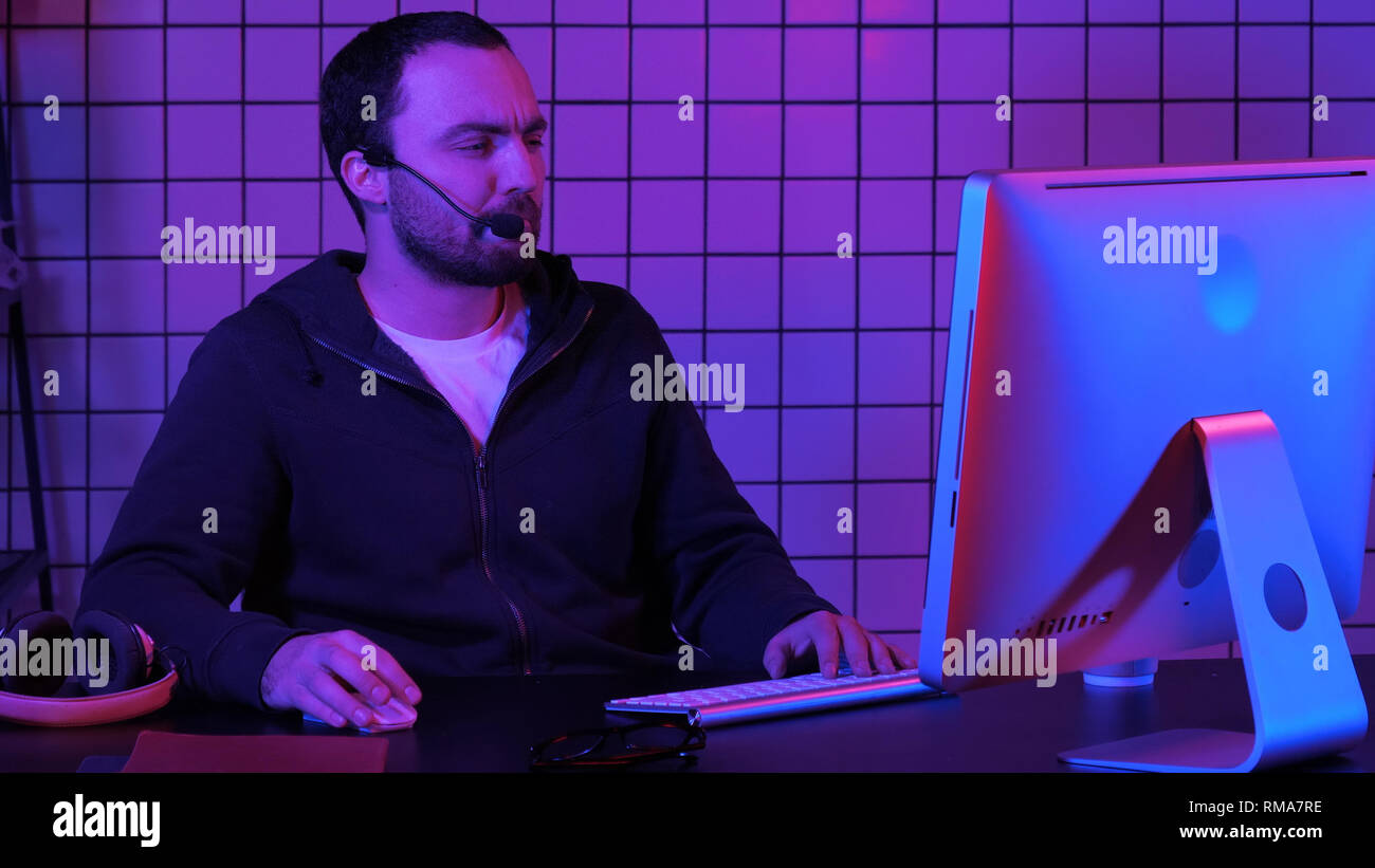 Young man programmer or hacker working on computer at night. Stock Photo