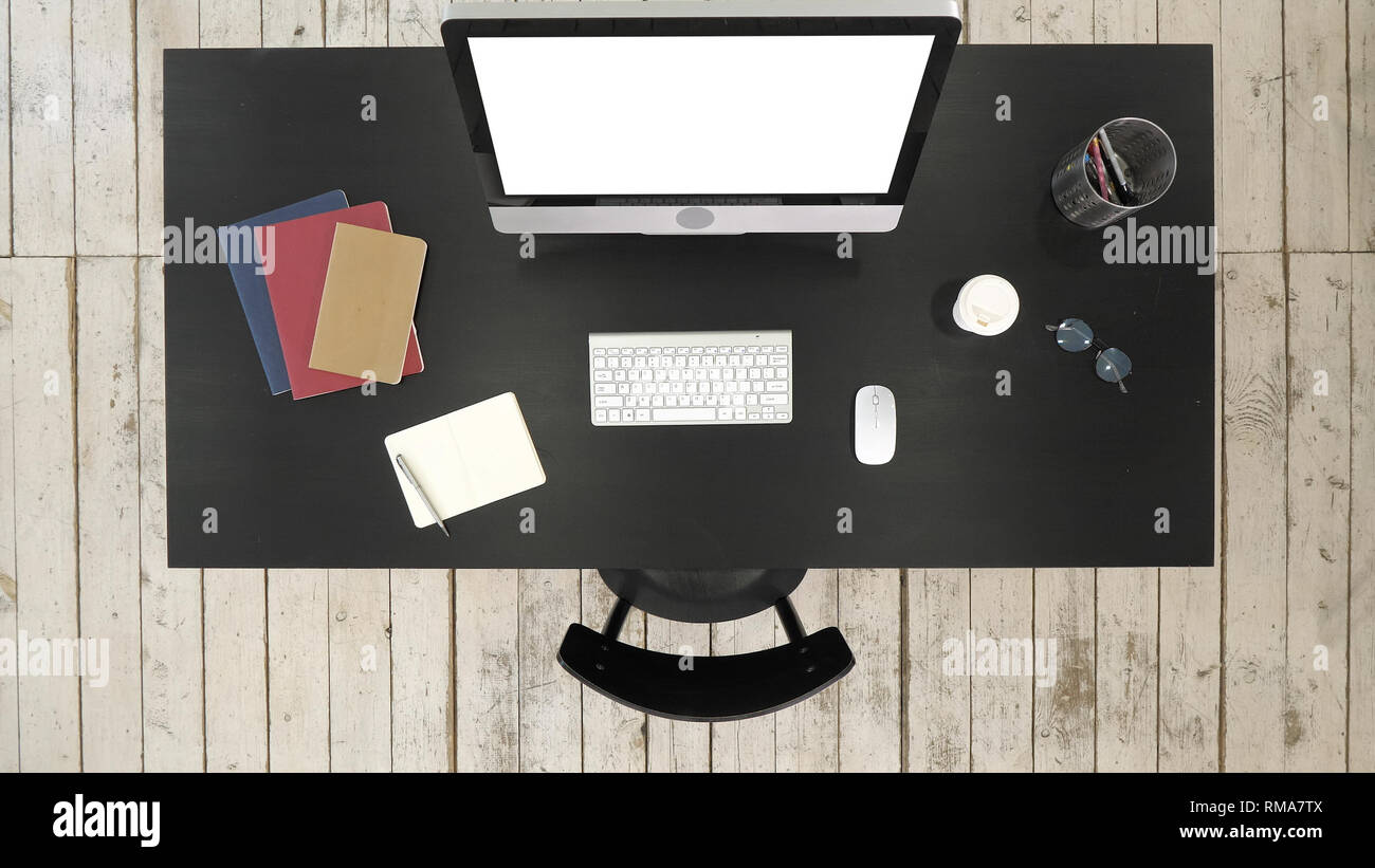 Office desk with computer and screen seen to camera. White Display