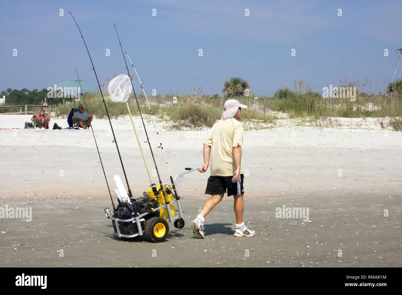 Man with fishing equipment on the beach Stock Photo