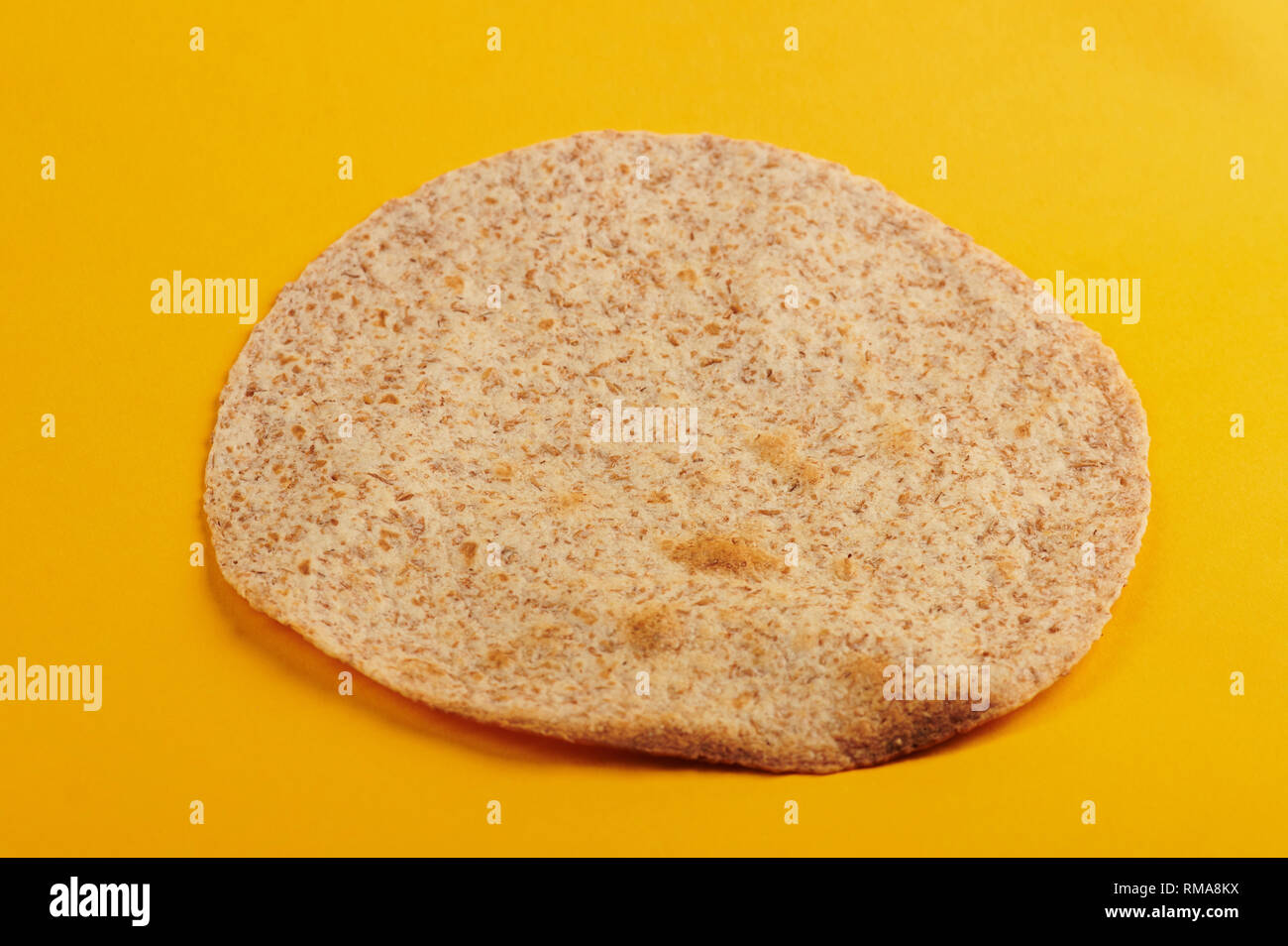 Toasted tortilla on yellow background angle view Stock Photo
