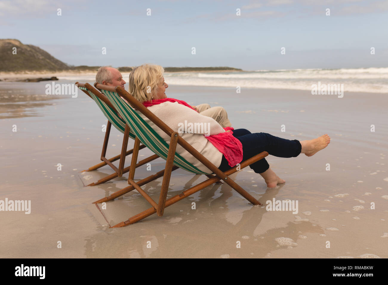 Senior couple relaxing in a sun lounger on the beach Stock Photo - Alamy