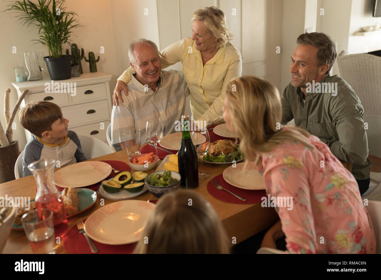 Family interacting with each other while having meal Stock Photo