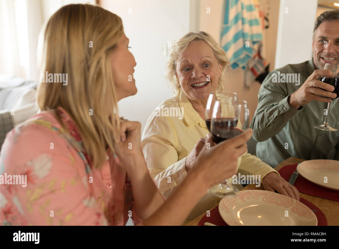 Family toasting glasses of wine on dining table Stock Photo