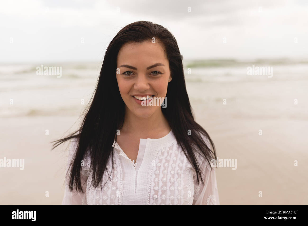 Happy woman standing on the beach Stock Photo - Alamy