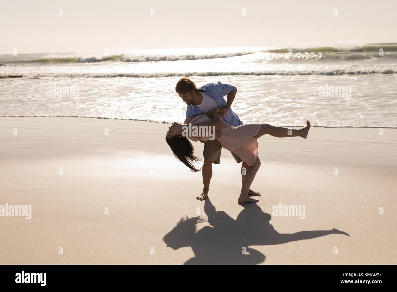 Romantic young couple dancing on beach Stock Photo