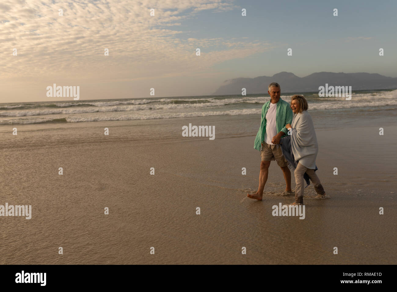 Senior couple walking hand in hand on the beach Stock Photo - Alamy