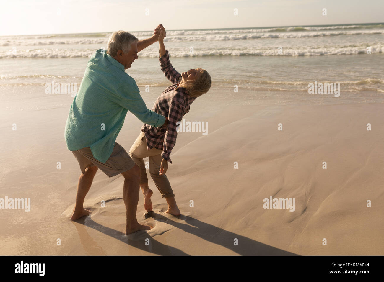 Senior couple dancing together on the beach Stock Photo