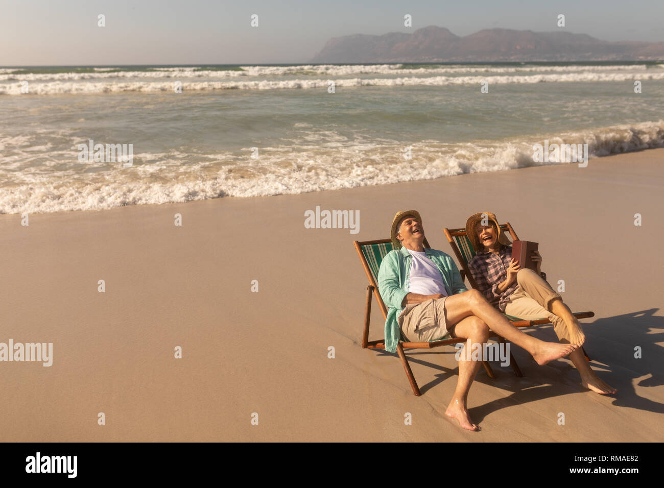 Senior couple having fun while relaxing on sun lounger at beach Stock ...
