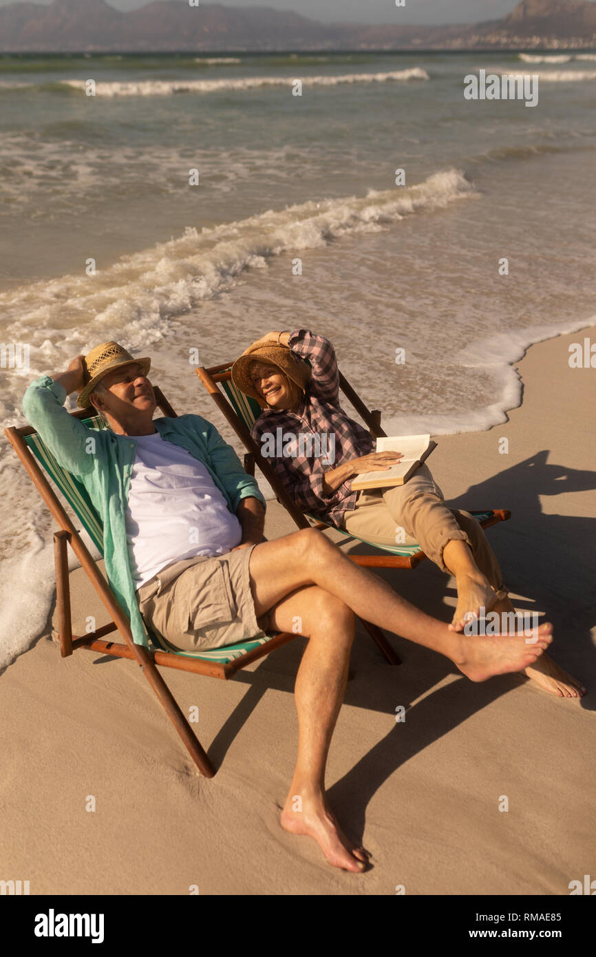 Senior couple having fun while relaxing on sun lounger at beach Stock ...
