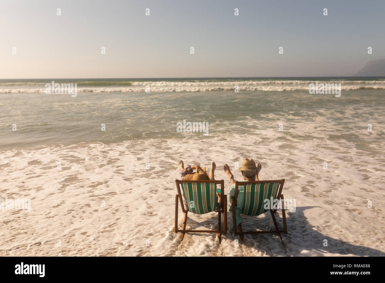 Senior couple relaxing together on sun lounger at beach Stock Photo - Alamy