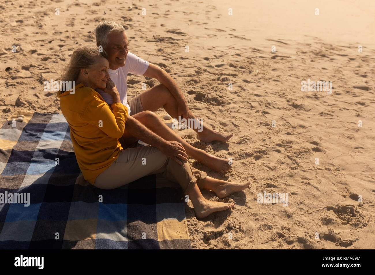 Senior couple relaxing on picnic blanket at beach Stock Photo - Alamy