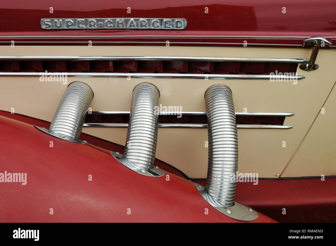 Detail of the chrome-plated external exhaust pipes on a classic Supercharged Auburn automobile. Stock Photo