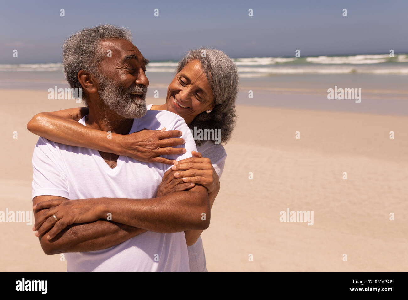 Senior woman embracing senior man on beach Stock Photo