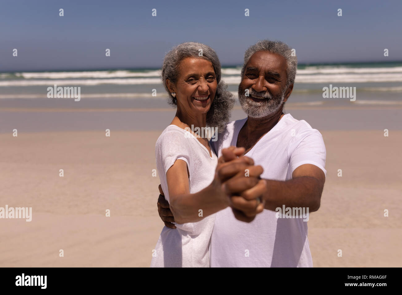 Senior couple dancing together on beach Stock Photo