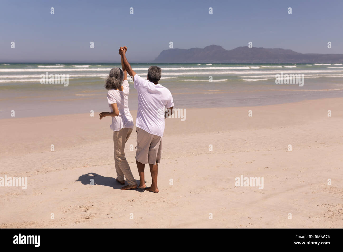 Senior couple dancing together on beach Stock Photo