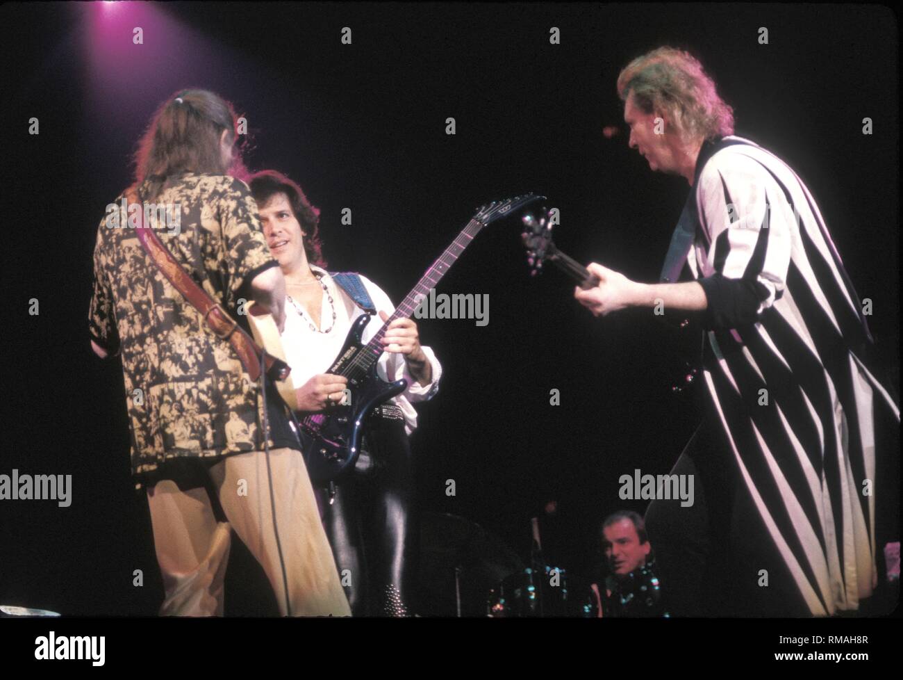 Musicians Steve Howe, Trevor Rabin and Chris Squire of the progressive rock band Yes are shown performing on stage during a 'live' concert appearance. Stock Photo