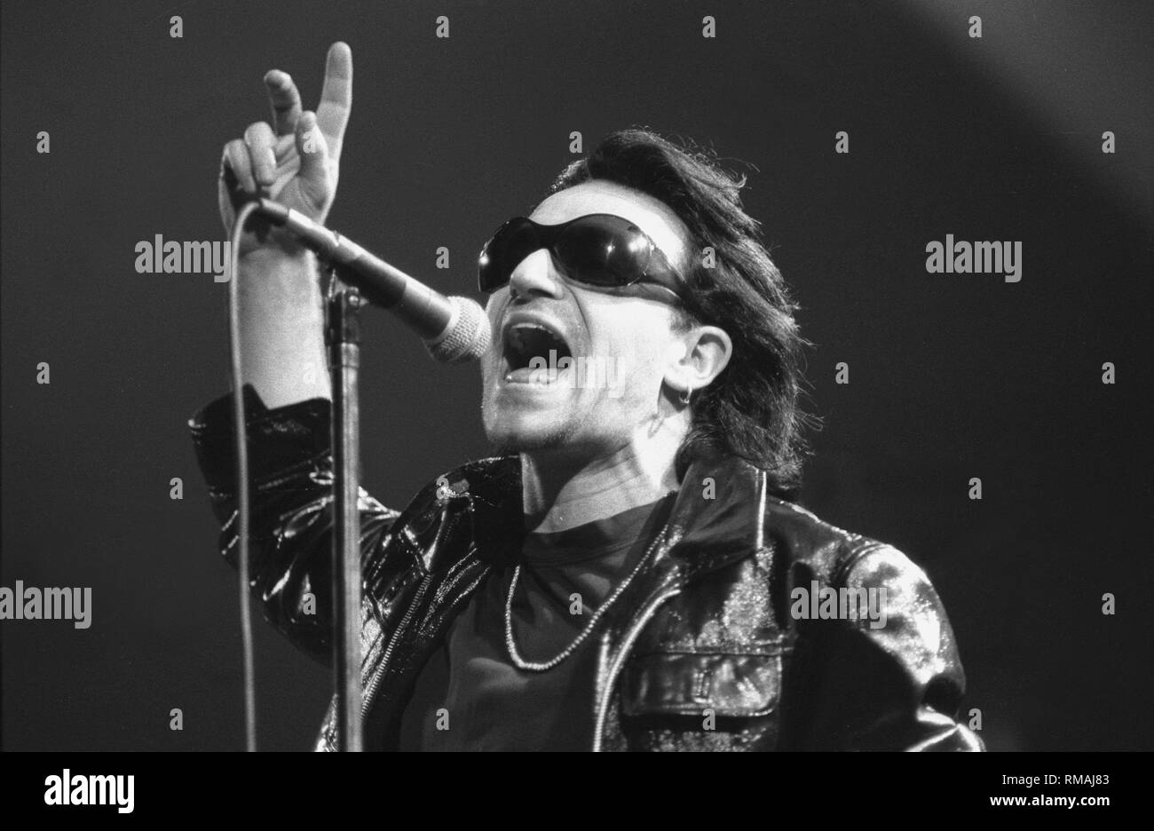 Singer Paul Hewson also, best known by his stage name Bono, of the Irish rock band U2, is shown performing on stage during a 'live' concert appearance. Stock Photo