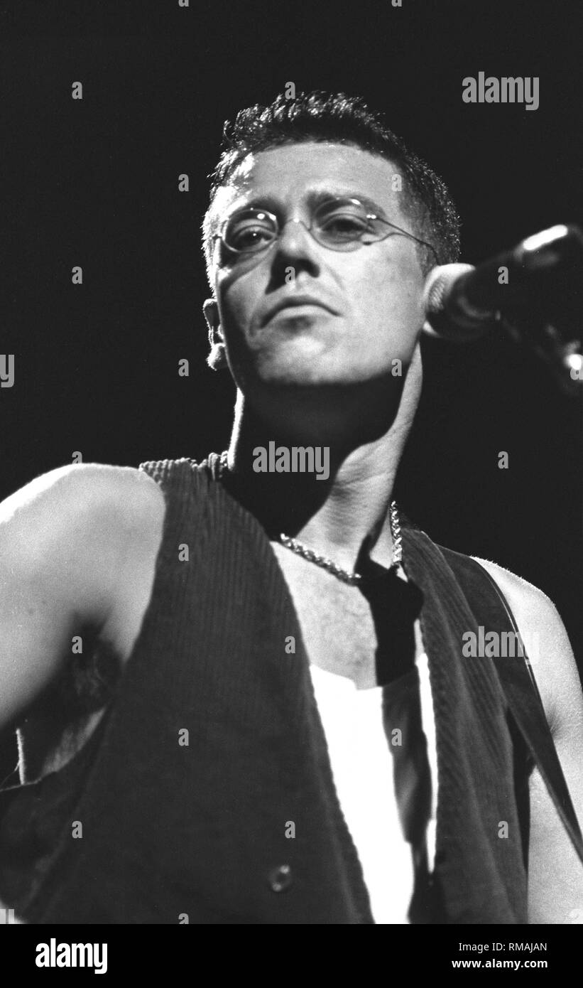 Bassist Adam Clayton is shown performing on stage during a 'live' concert appearance with U2. Stock Photo