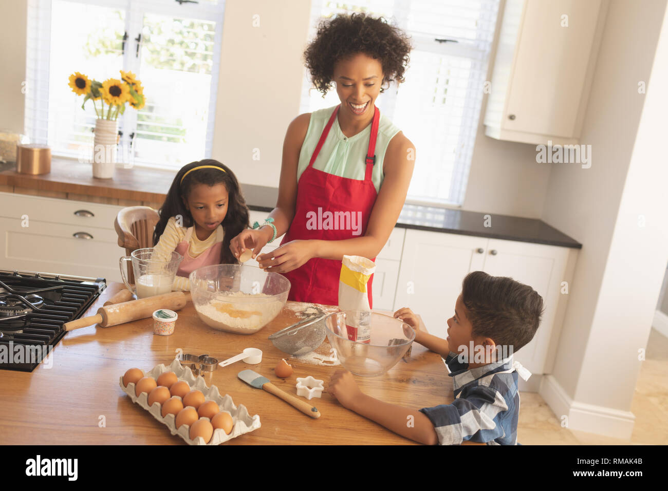 African American mother and children baking cookies in kitchen Stock Photo