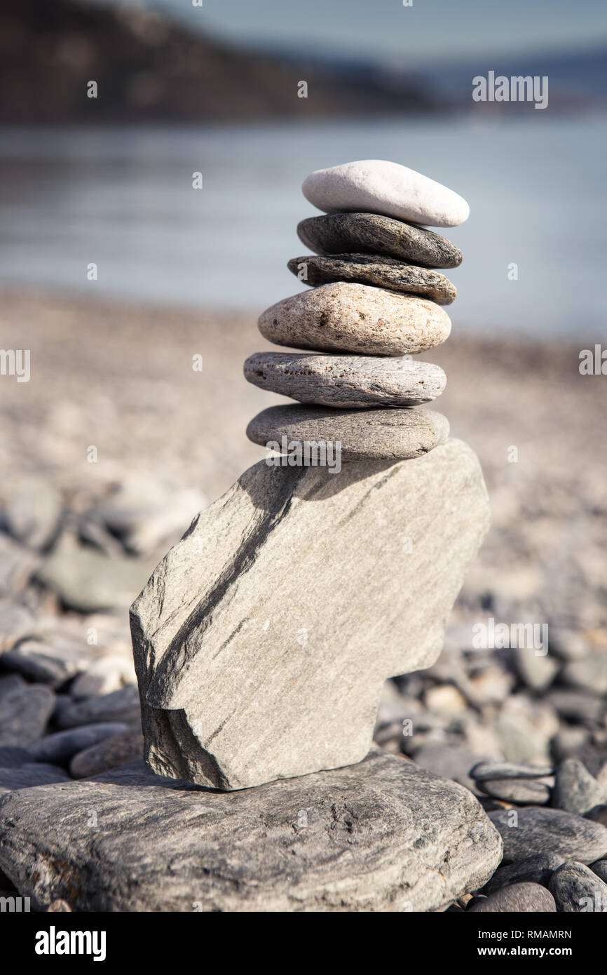 Rock balancing or stone balancin, naturally balanced on a beach with ...