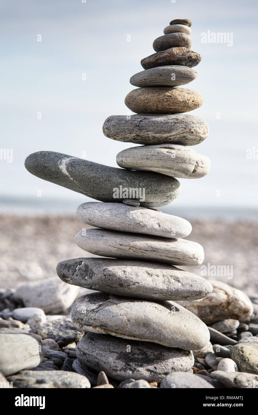 Rock balancing or stone balancin, naturally balanced on a beach with ...