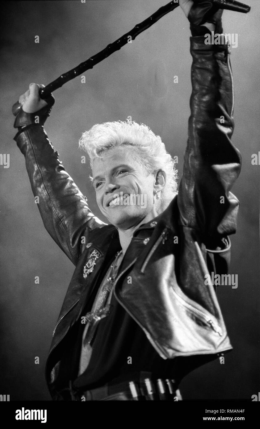 Singer Billy Idol is shown performing on stage during a "live" concert