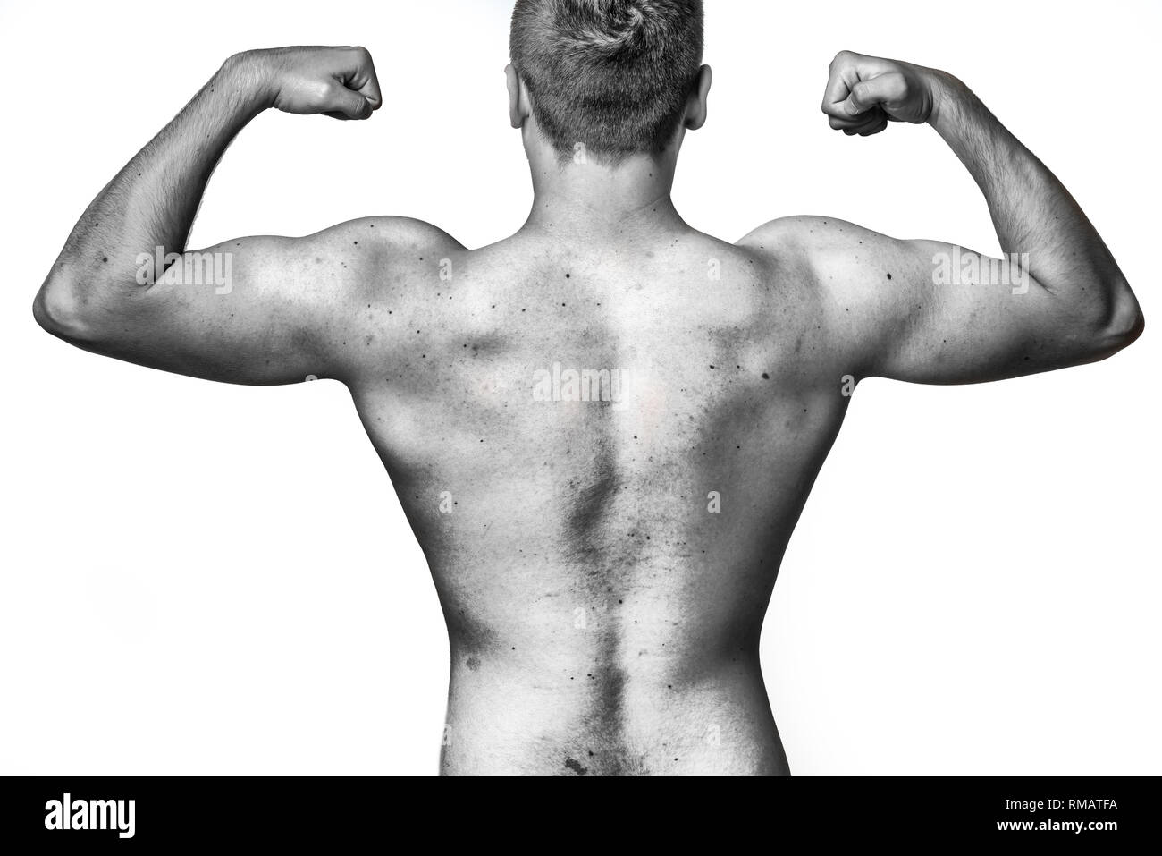 Fit muscular young man flexing his muscles raising his arms with