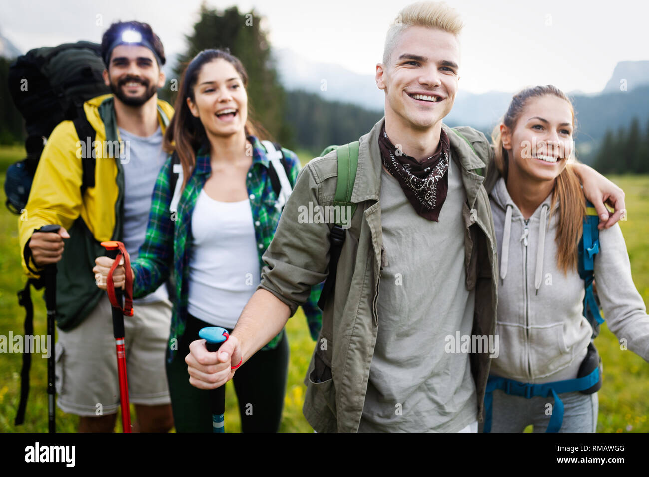 Group of hikers walking on a mountain and smiling Stock Photo - Alamy