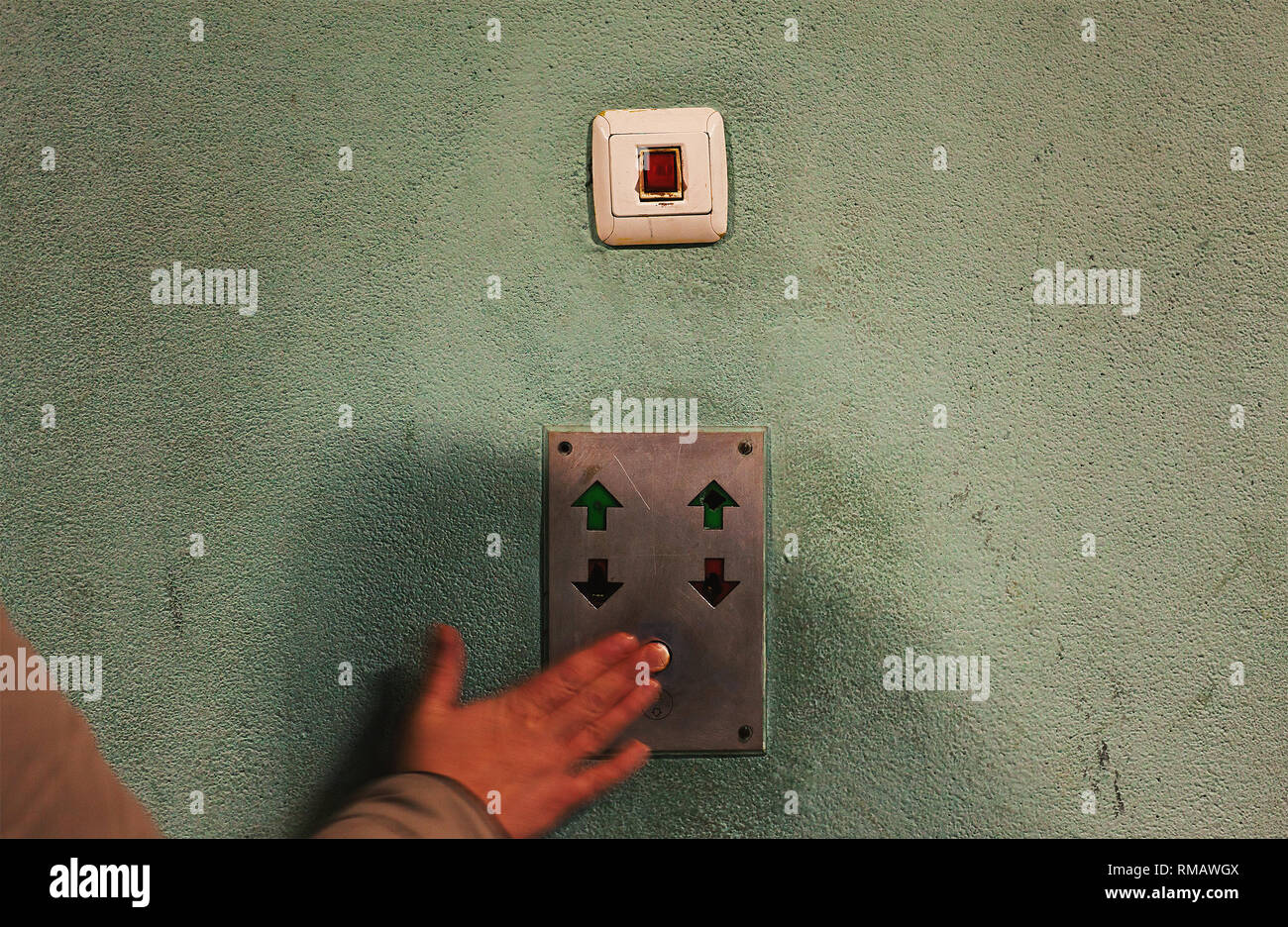 Pushing an old elevator button, details of an old retro technology and wall. Stock Photo