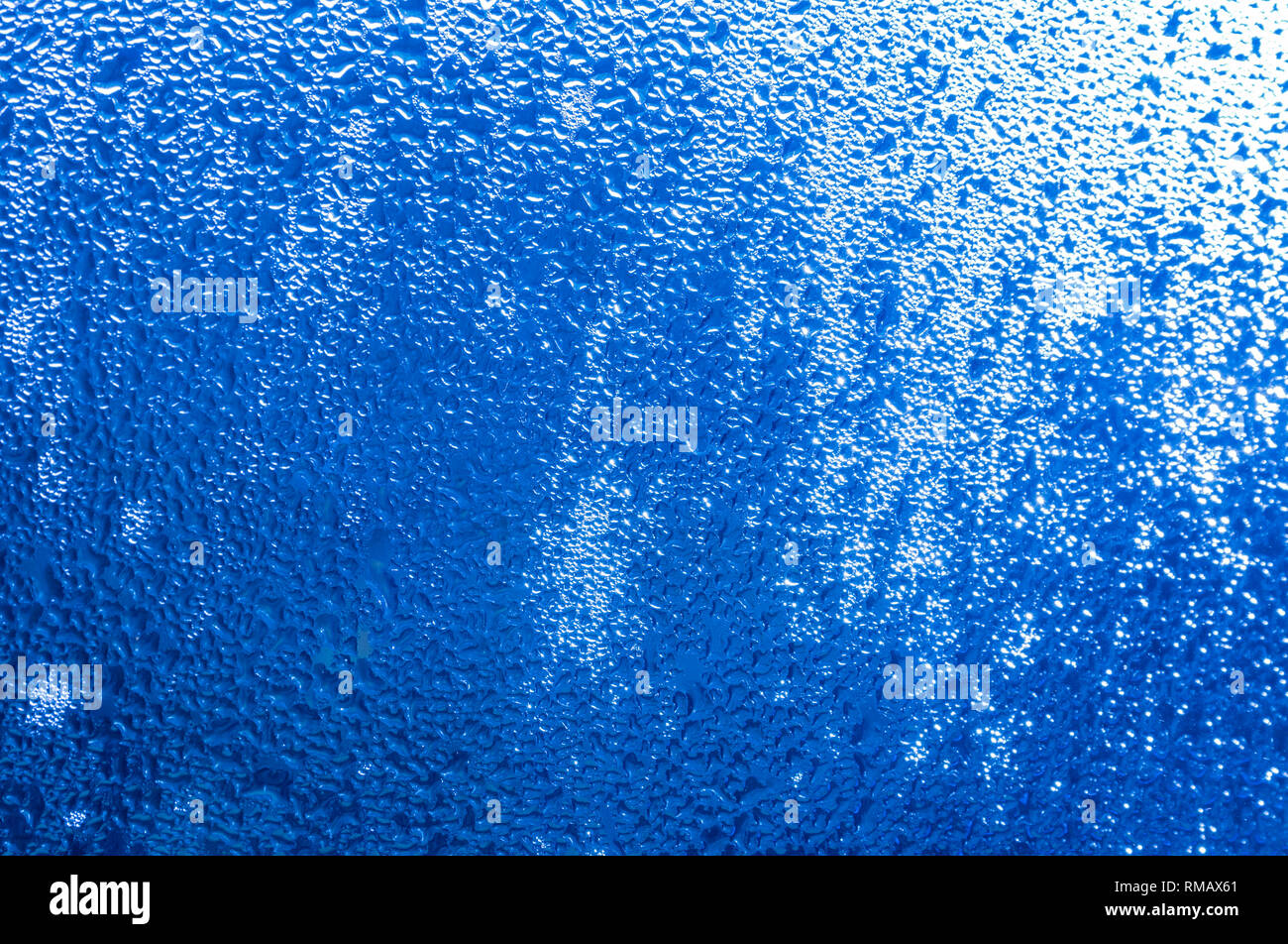 Blue abstract image of condensation on a window in the morning. Stock Photo