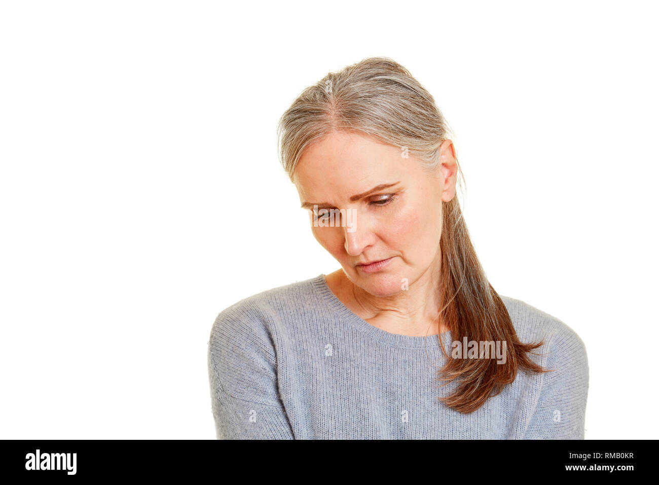 Old woman looks down sadly and depressed Stock Photo